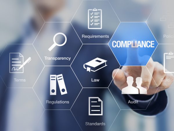 Compliance concept with icons for regulations, law, standards, requirements and audit on a virtual screen with a business person touching a button
